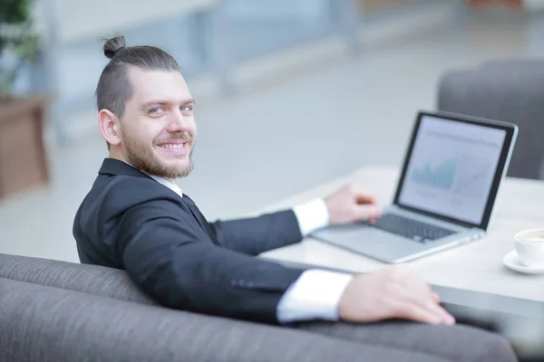 Portrait of a smiling businessman sitting at a Desk. — Stock Photo, Image
