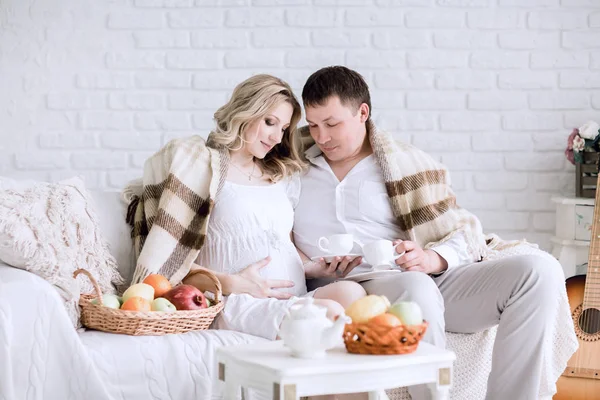 Gelukkig man kijken naar de buik van zijn zwangere wifes — Stockfoto