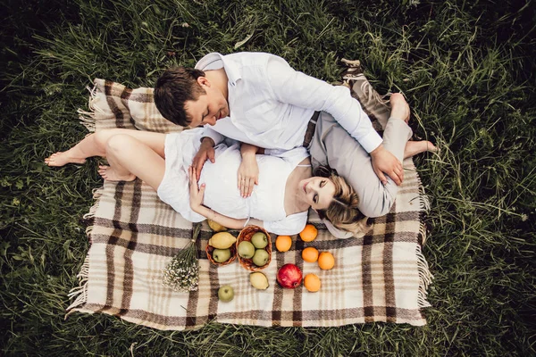 野餐时幸福的家庭躺在毯子上 — 图库照片