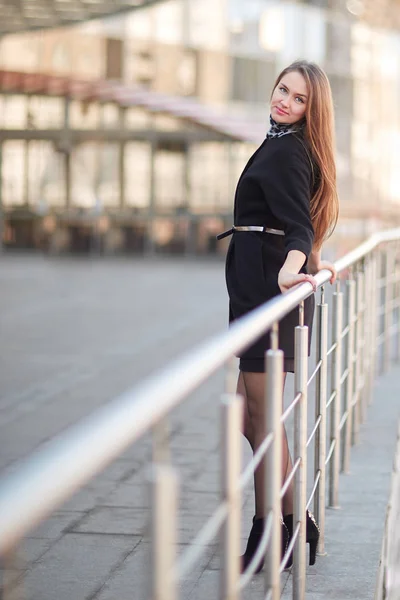 Kendine güvenen genç iş kadını modern ofis binası yanında ayakta. — Stok fotoğraf