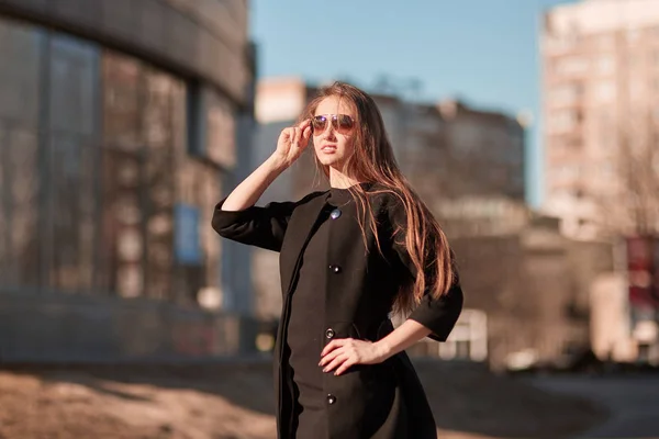 Glad ung kvinna stående på gatan av modern stad — Stockfoto