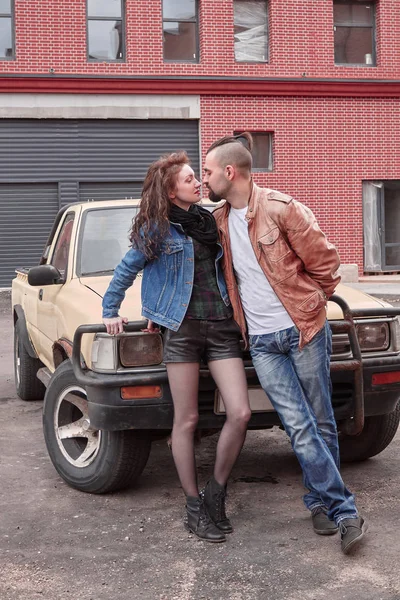 年轻夫妇站在附近的汽车在城市停车场 — 图库照片