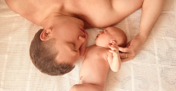 Padre y su hija recién nacida duermen dulcemente en la cama —  Fotos de Stock