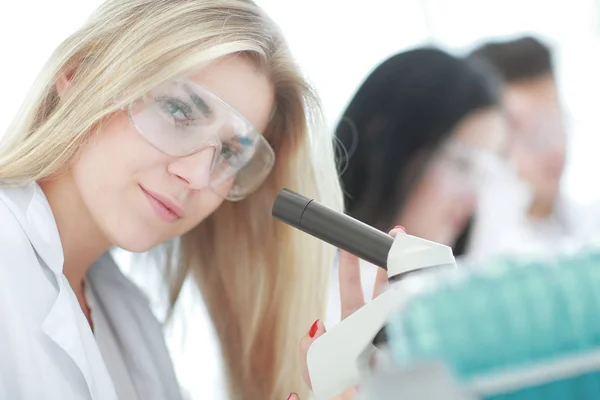 Nauwe up.a moderne vrouwelijke wetenschapper kijkt naar een microscoop in een laboratorium — Stockfoto