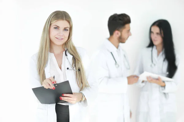 Ernstige therapeut met een klembord terwijl hij in de kliniek staat — Stockfoto