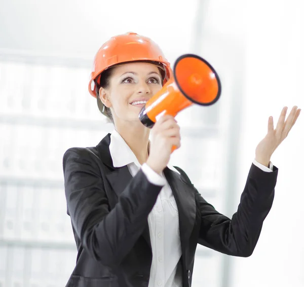 Självsäker kvinnlig ingenjör med en megafon på bakgrunden av kontoret. — Stockfoto