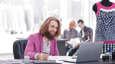 stüdyoda bir masada oturan bir grafik tablet Moda Tasarımcısı kullanır