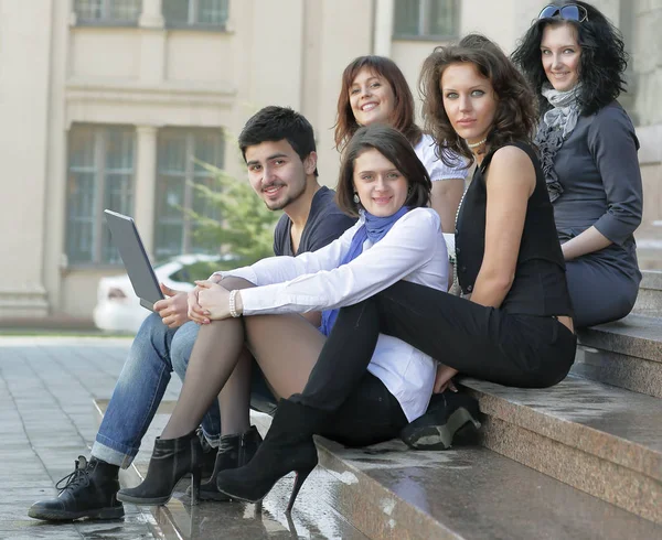 Retrato de un grupo de estudiantes sentados frente a la Universidad —  Fotos de Stock