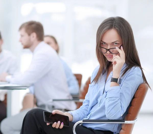 Ejecutiva mujer de negocios con teléfono inteligente en fondo borroso del equipo de negocios —  Fotos de Stock