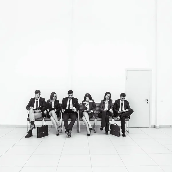 Equipo de negocios que trabaja con documentos antes de la sesión de trabajo sentado en sillas de oficina frente a la sala de conferencias — Foto de Stock