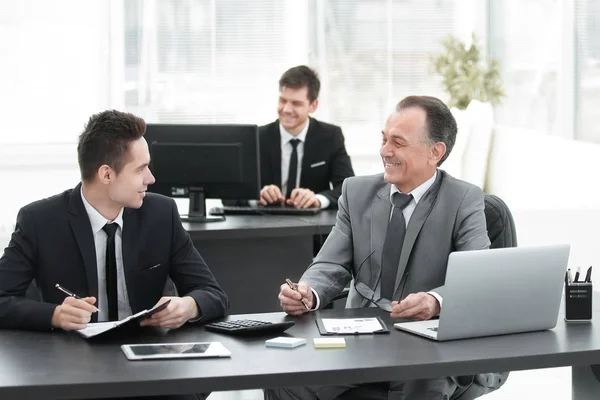 Colegas de negocios sentados en un escritorio en la oficina . — Foto de Stock