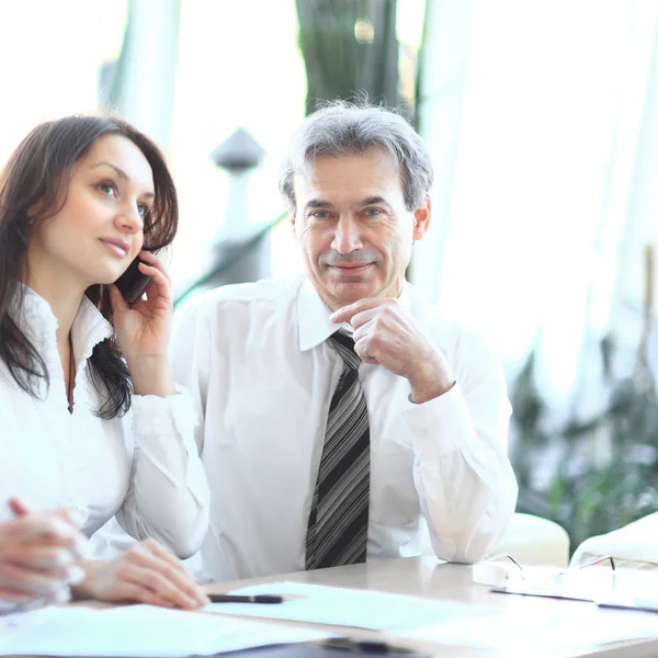 Collega's analyseren van financiële statistieken zitten aan een bureau — Stockfoto