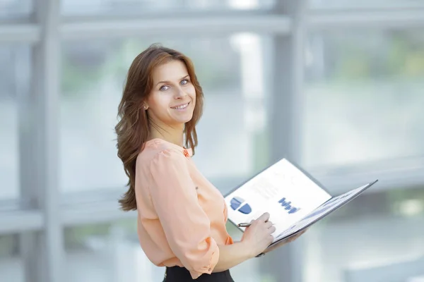 Posteriore view.a giovane donna d'affari in possesso di una cartella con documenti finanziari — Foto Stock