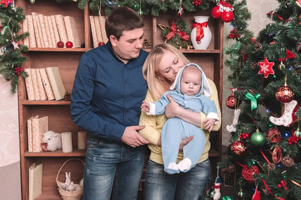 Boldog szülők és a baba áll a karácsonyfa mellett — Stock Fotó