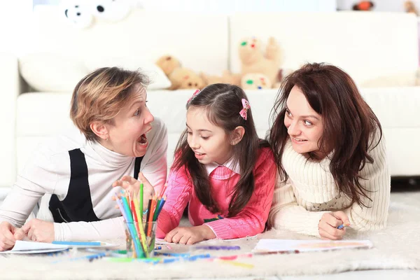 Niña dibuja con su madre y su abuela — Foto de Stock