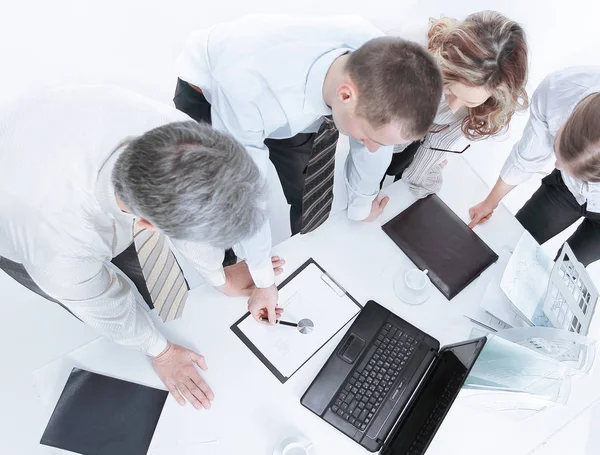 Бизнес-команда, работающая во время обсуждения финансовых документов, стоящая рядом с рабочим столом — стоковое фото