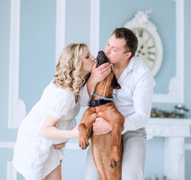 Genç evli bir çift onların evde beslenen hayvan öpüşme portresi