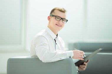 Ofis lobisinde oturan ve işletme belgesi okuma işadamı