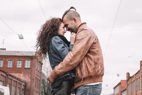 Pareja en el amor abrazos entre sí mientras que de pie en una calle de la ciudad — Foto de Stock