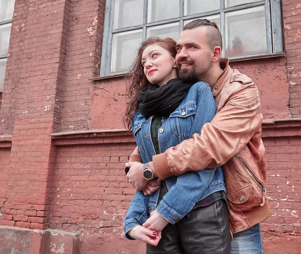 Gelukkig jongeman knuffels zijn vriendin op een stad straat — Stockfoto