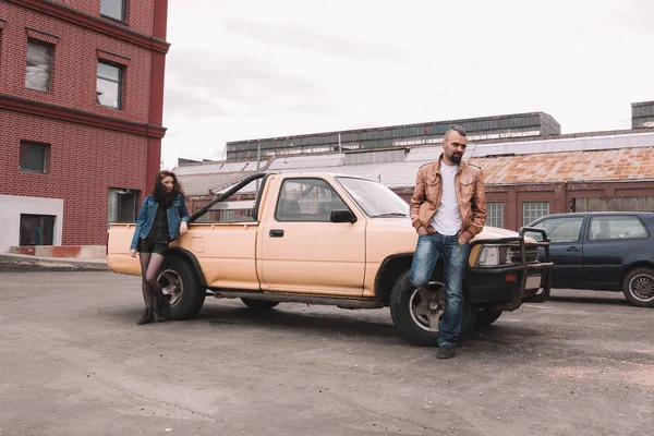 Frustriertes junges Paar steht neben seinem Auto — Stockfoto