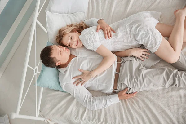 Glücklicher Mann und Frau auf dem Bett liegend — Stockfoto