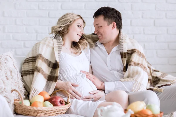 Gelukkig man kijken naar de buik van zijn zwangere wifes — Stockfoto