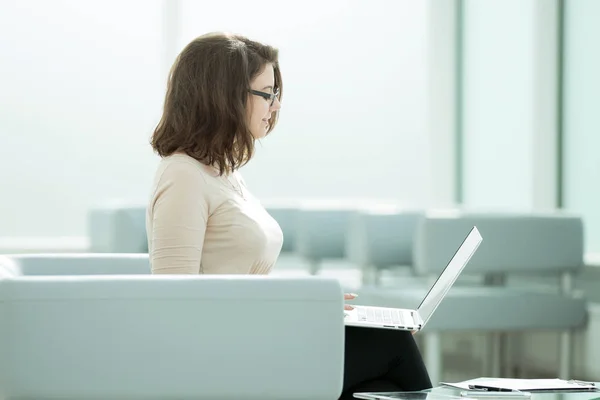 Iş kadını mali belgelerle çalışmak için bir dizüstü bilgisayar kullanarak — Stok fotoğraf