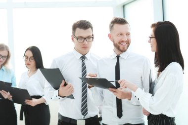 ofiste iş belgeleri tartışırken çalışanlar