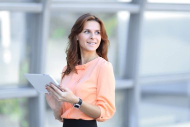 Kendine güvenen iş kadını bulanık office arka plan üzerinde dijital tablet ile.