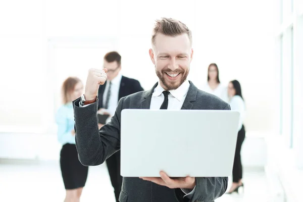 Homem de negócios muito feliz com laptop no fundo do escritório leve  . — Fotografia de Stock