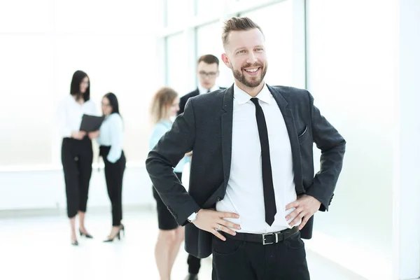 Sorridente empresário no fundo de um escritório brilhante — Fotografia de Stock