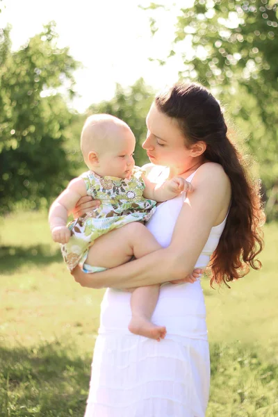 Happy mother holds a little daughter in her arms — Stock Photo, Image