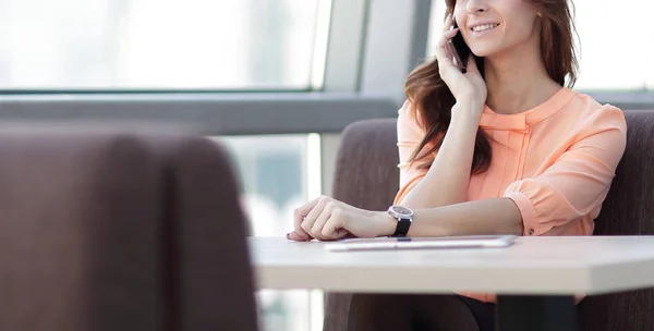 Mujer consultora con teléfono inteligente sentado en su escritorio en la oficina — Foto de Stock