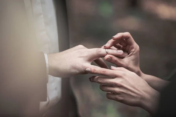 Nahaufnahme des Bräutigams legt den Ring auf den Finger der Braut. — Stockfoto