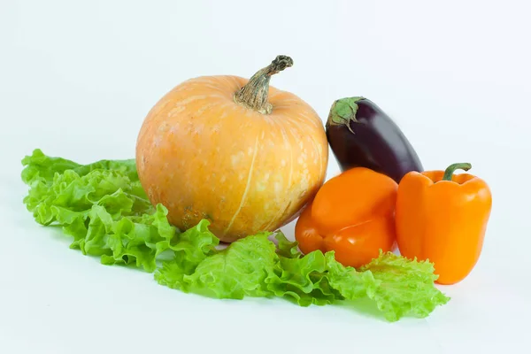 Citrouille, poivron, aubergine sur feuilles de laitue .isolated sur blanc . — Photo