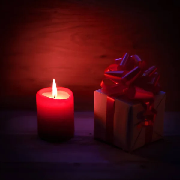 Dvě svíčky a vánoční dárek na dovolené pozadí. — Stock fotografie