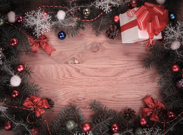 Рождественский венок и подарок на деревянном фоне — стоковое фото