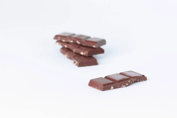 Stapel stukken van chocolade met noten geïsoleerd op wit — Stockfoto