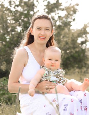 Şehir Park arka plan üzerinde bir bebekle genç kadın