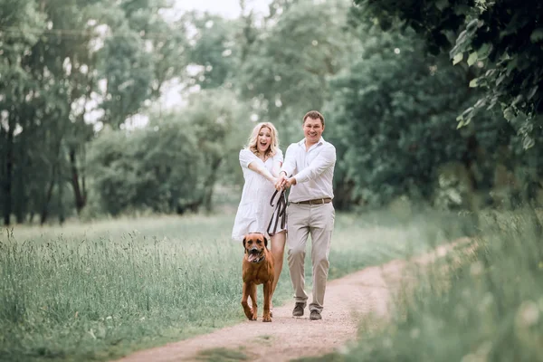 若い夫と彼の妻は、ペットの犬と楽しい時を過す — ストック写真