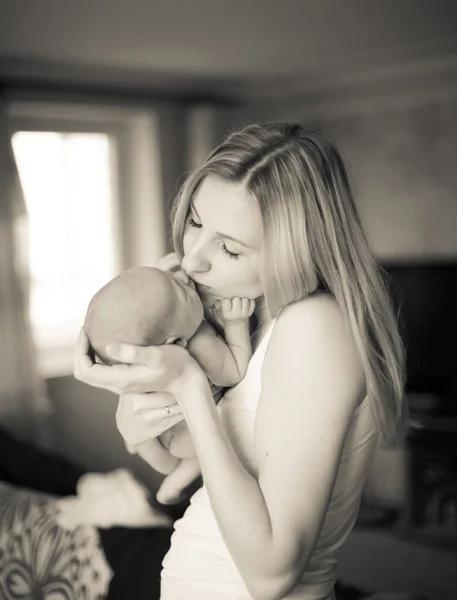 Foto retro. feliz madre besando a su hija recién nacida — Foto de Stock