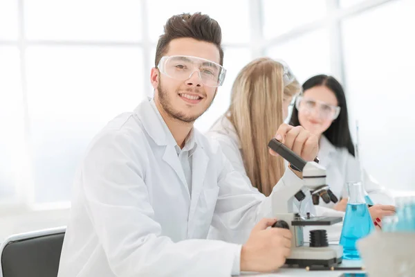Wetenschappers biologen zitten aan de laboratoriumtafel. — Stockfoto