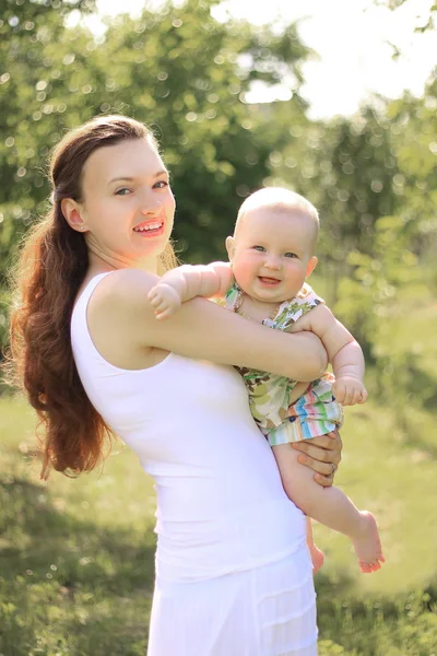 Madre sorridente e felice figlia di un anno in una passeggiata nel parco — Foto Stock