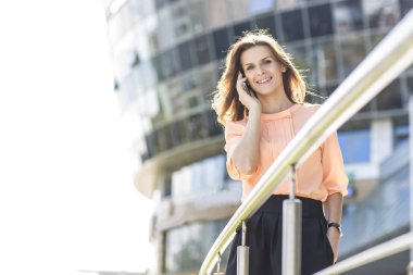 başarılı iş kadın smartphone cep telefonu ile bir büyük modern ofis binası önünde söz