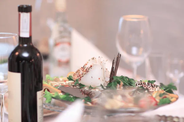 Up.a şişe şarap ve bir aperatif şenlikli masaya yakın — Stok fotoğraf