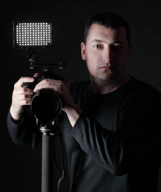 tripod.isolated siyah arka plan üzerine kamera ile profesyonel fotoğrafçı