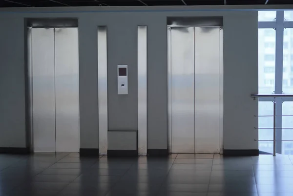 Puertas de ascensor cerradas y panel de control en un moderno edificio de oficinas —  Fotos de Stock