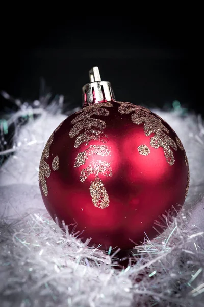 Hermosa bola de Navidad roja sobre un fondo negro. — Foto de Stock