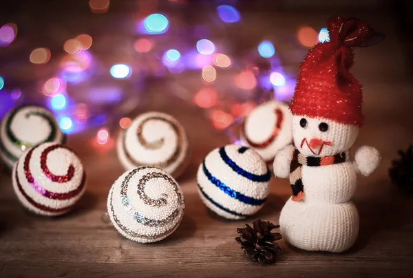 Kerstballen en een speelgoed sneeuwpop op kersttafel — Stockfoto